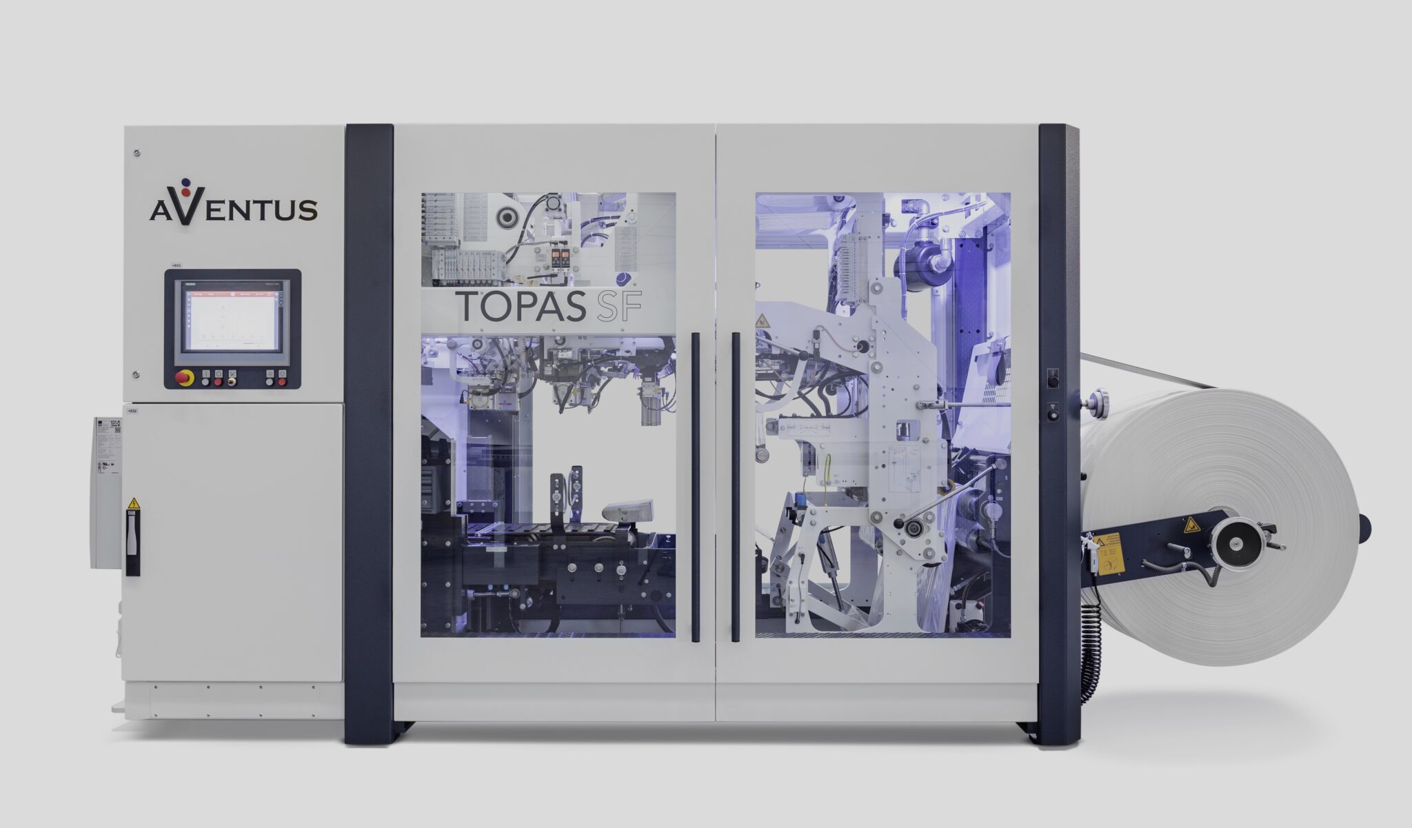 Eine große industrielle Verpackungsmaschine mit der Bezeichnung AVENTUS TOPAS SF verarbeitet eine Rolle weißes Material. Sie verfügt über eine Anbindung von Maschinen an eine Edge Plattform, deren Bedienfeld und mechanische Komponenten durch transparente Paneele sichtbar sind.